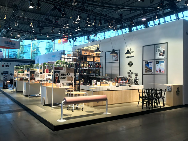 Messestand Kaffeewerkstatt, Stahlregale, Werkstattwagen, Klicklinoleum, geflieste Theke, Durchreiche, verputzte Kabine, Fenster, Anlehnhocker, Beistelltische